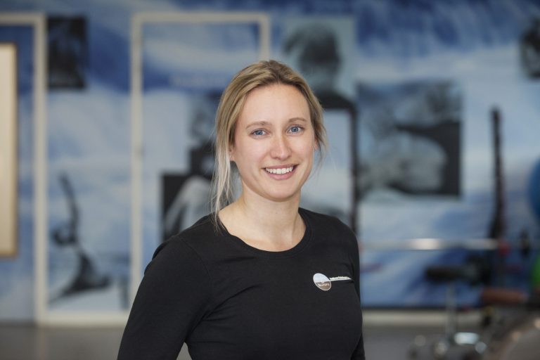 therapeut kijkt blij omdat ze covid patient heeft geholpen