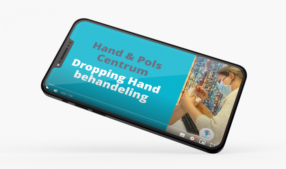 Op een telefoon wordt een video afgespeeld van Hand & Pols Centrum over Dropping Hand behandeling