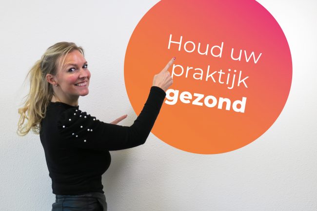 kirsten wijst naar een bord met de tekst houd uw praktijk gezond