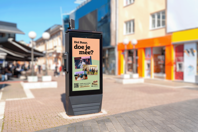 Een staand billboard midden in een centrum met daarop een advertentie voor Hoi Buur